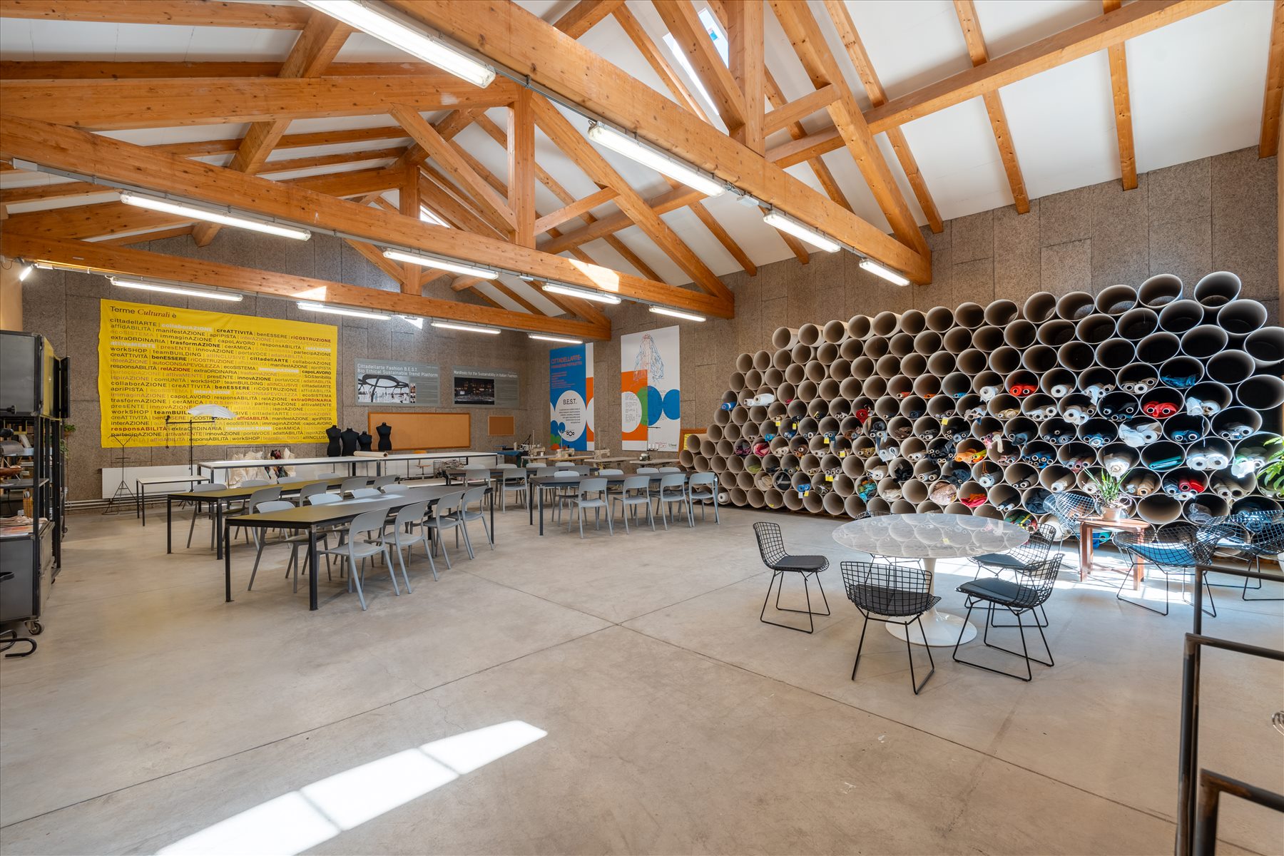 Sala Best con tavoli, filati e installazioni tessili.