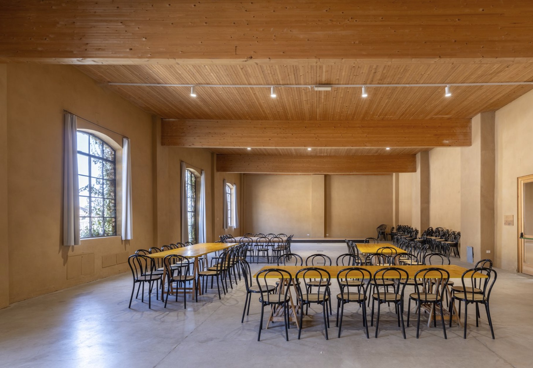 Sala Cervo con tavoli gialli e sedute in assetto pronto.